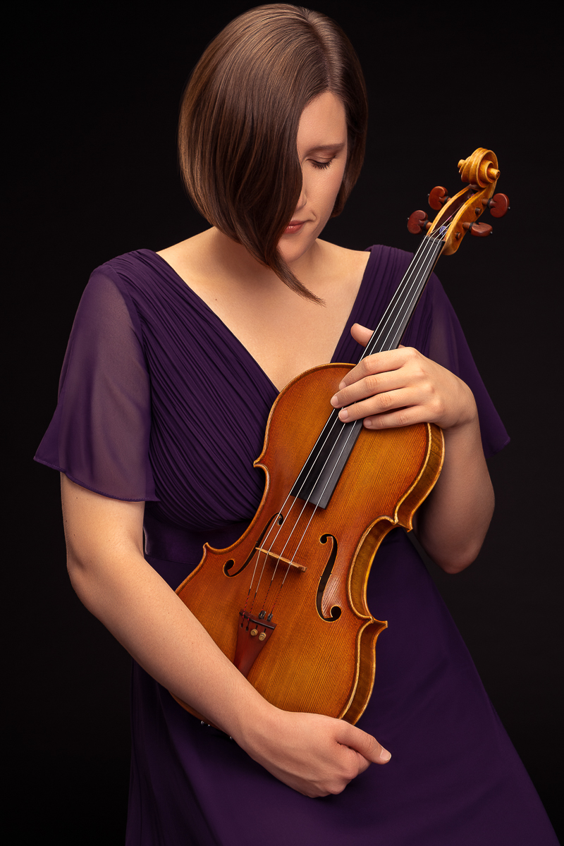 Ritratto verticale in studio di Elena Da Pieve con la viola su fondo nero