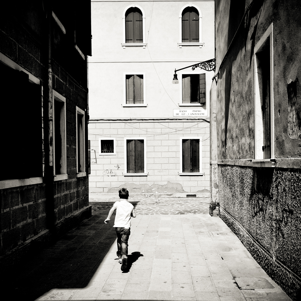 Bambino in un campo veneziano inserito nello spazio urbano